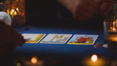 Nahaufnahme-Einer-Frau,-Die-Einem-Mann-Am-Kerzenbeleuchteten-Tisch-Tarotkarten-Vorliest-6